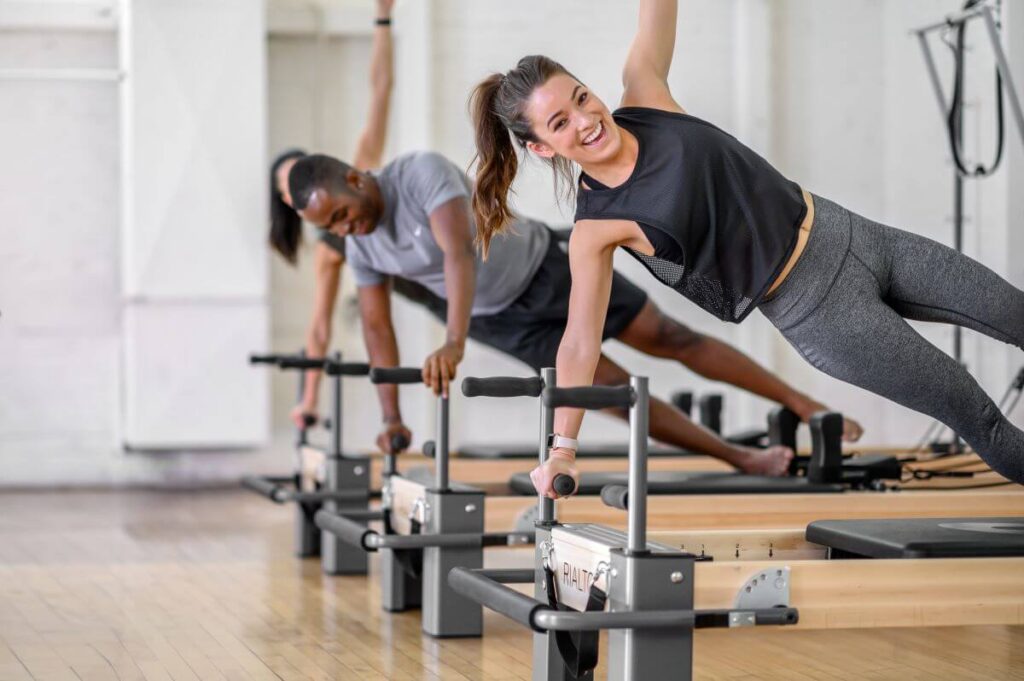 Ihmiset harjoittelevat Rialto Reformer Plank Barseilla studiolla.
