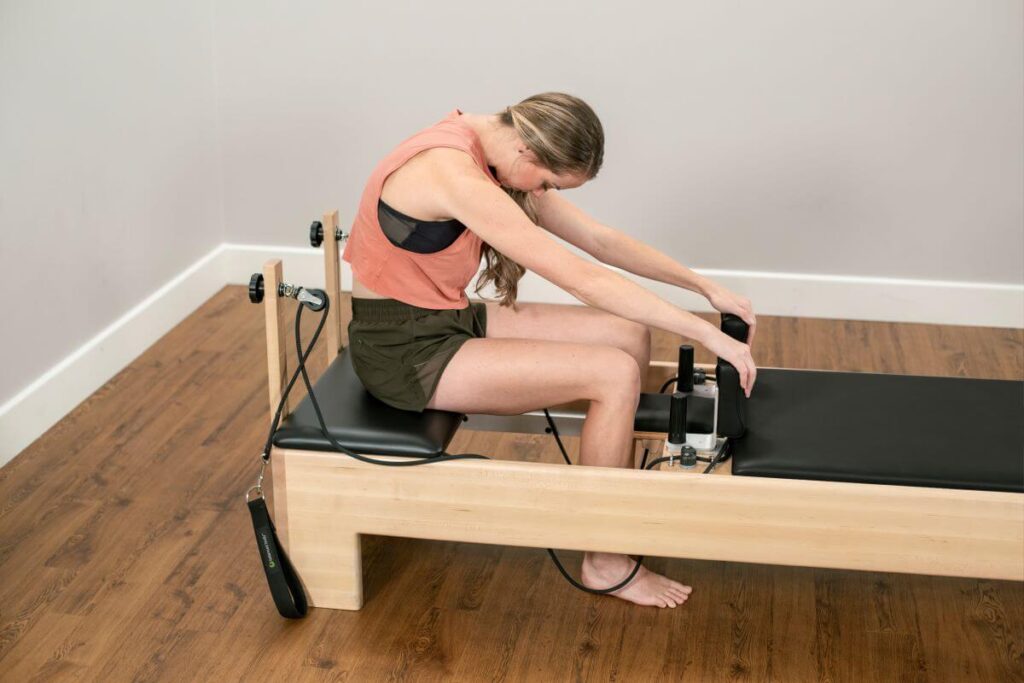 Woman using Studio Add-A-Platform on a Balanced Body Reformer.