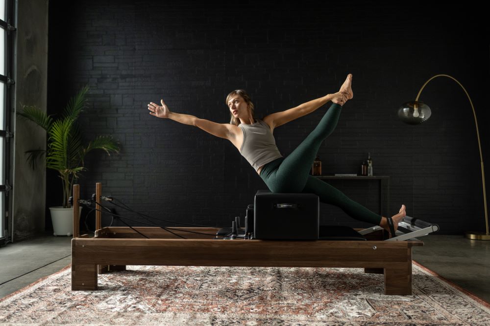 Woman exercising on Reformer with New York Sitting Box in studio.