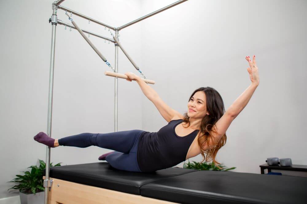 Woman exercising on Reformer Trapeze Combination in studio.