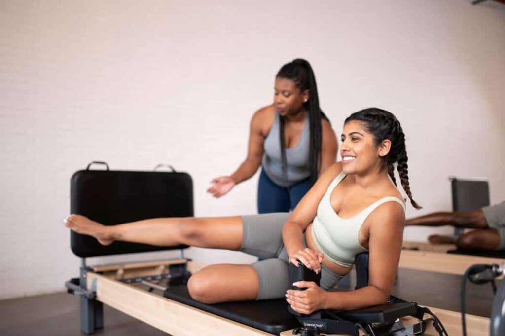 Pilates instructor guiding student on Rialto Reformer Jumpboard