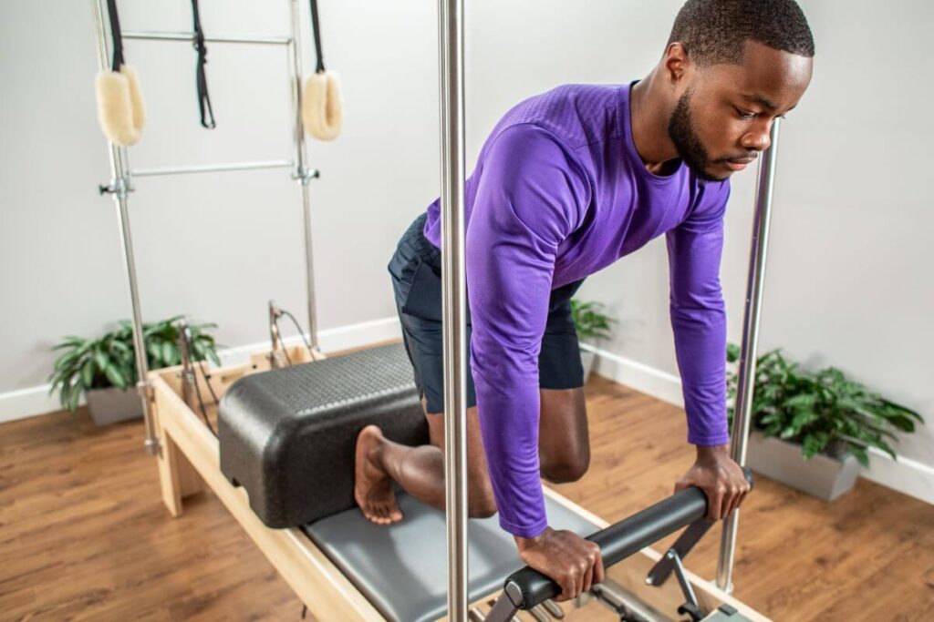 Man using Sitting Box Lite on Pilates reformer