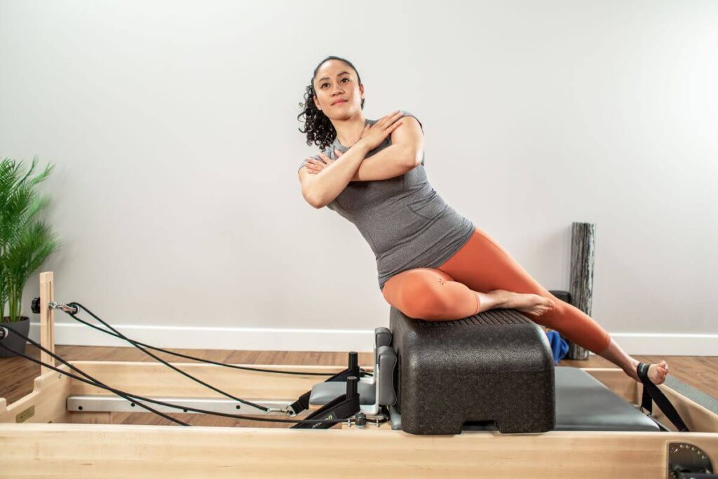 Woman exercising on Sitting Box Lite with reformer