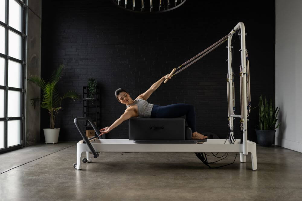 Pilates instructor using Standard Sitting Box on a reformer.