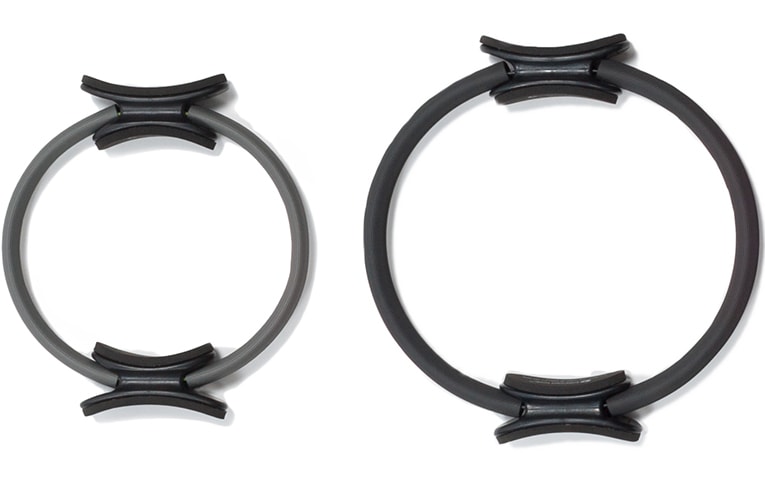 Two Pilates rings with padded handles, varying in size and resistance.