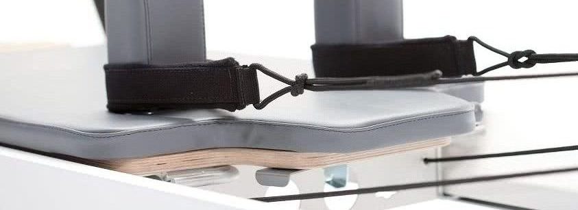 Professional Pilates carriage with integrated headrest and storm-colored upholstery.