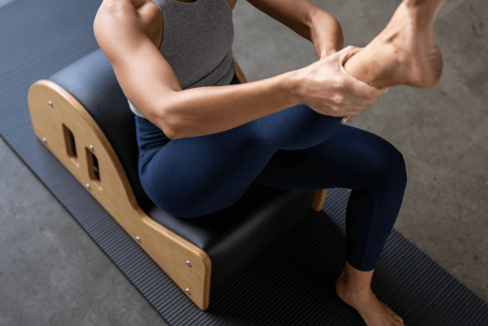 Person exercising on Clara Step Barrel with cut-out handholds.