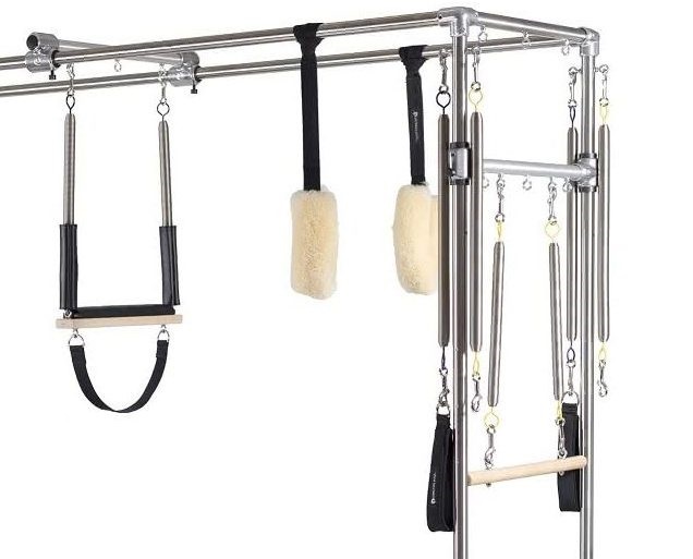Pilates equipment featuring PTB system with straps, handles, and bars