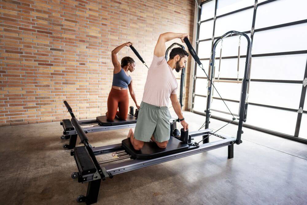 Two people using Allegro Nextgen Reformers with Towers in studio.