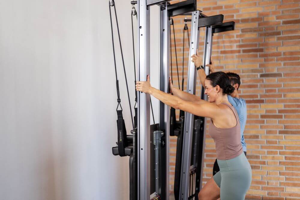 Two individuals using Allegro Nextgen Reformers in a Pilates studio.