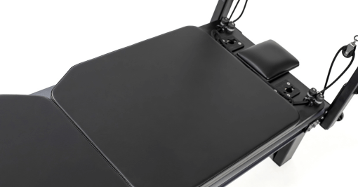 Pilates reformer with anti-slip mat for stable exercise surface