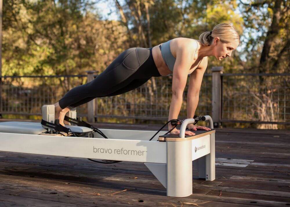 Person practicing on Bravo Reformer Extended Head End Platform outdoors.
