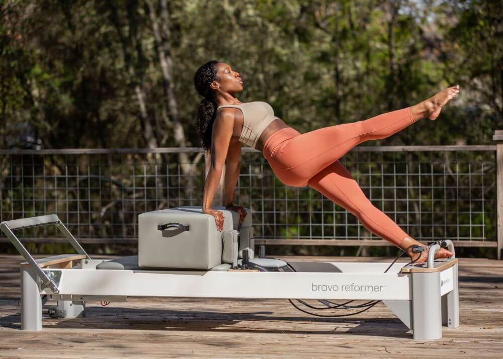 Pilates instructor using Bravo Reformer Extended Head End Platform.