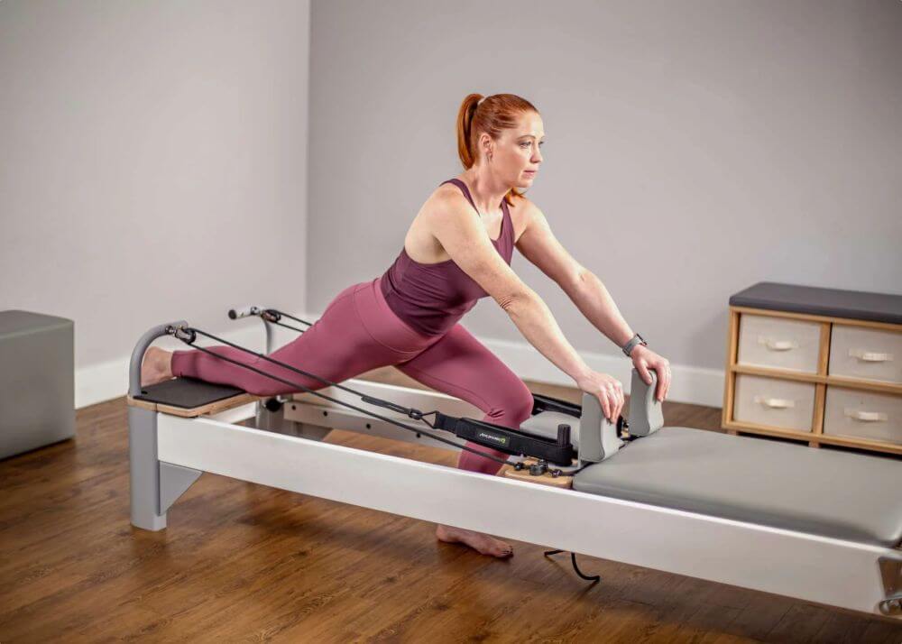 Woman stretching on Bravo Reformer Extended Head End Platform.