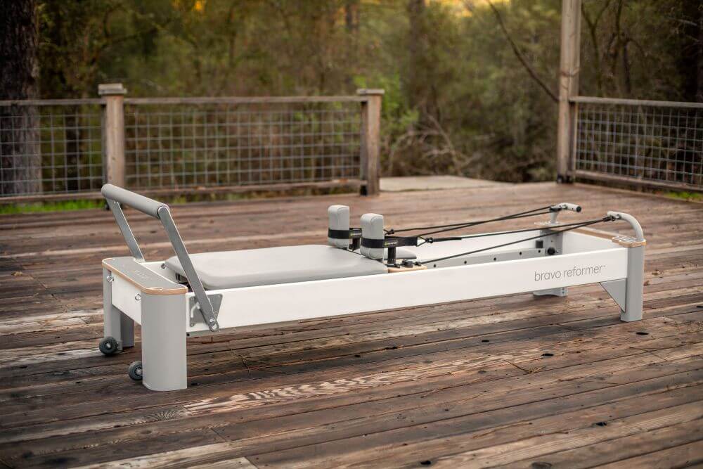 Bravo Reformer Pilates equipment on wooden deck, outdoor setting.