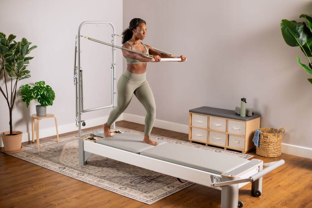 Bravo Reformer with Tower in use by an individual in a Pilates studio.