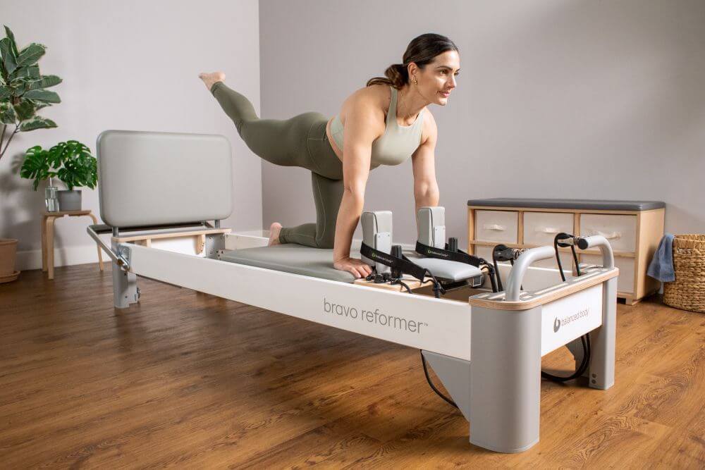 Woman performing Pilates on Bravo Reformer with Jumpboard
